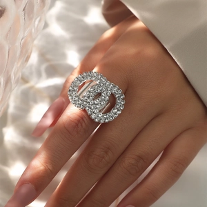 Macro detail of intertwined silver rings with pavé set sparkling crystals on a hand