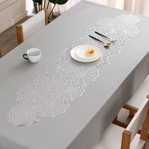 Macro view of white lace spider web table runner with gold stamping for Halloween decor