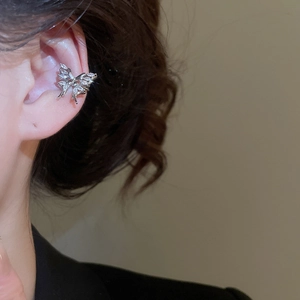Detail view of a silver zircon butterfly cuff earring worn by a model on the ear