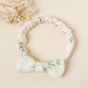 Close-up of baby cotton headband with green leaf print and cute bow detail