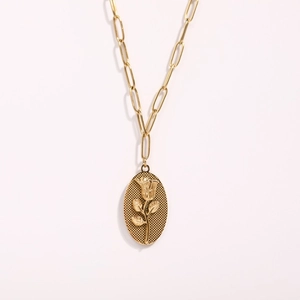 Detail of vintage gold oval necklace featuring embossed rose and grid texture