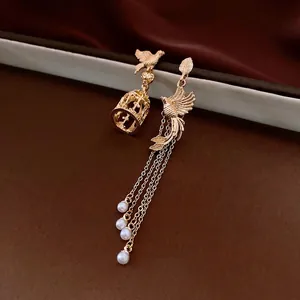 Asymmetric gold birdcage earrings with pearls and tassels for a vintage elegant look