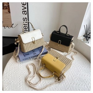 Detail of straw woven crossbody bags in beige, black, and yellow with gold oval metal locks