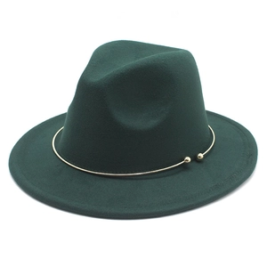 Detailed view of forest green felt fedora hat with elegant gold metal ring band decoration