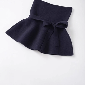 Navy blue knit peplum top with lace-up bow and ruffled hem on white background