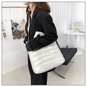 Detail shot of a silver quilted puffer tote bag with glossy metallic finish and soft padding