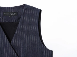 Detail of V-neckline and shoulder cut on dark pinstripe linen blend vest with woven texture