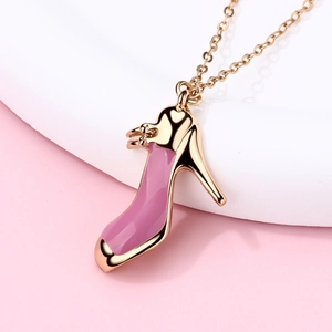 Collana a catena dorata con pendente a scarpa con tacco rosa in smalto su sfondo rosa tenue
