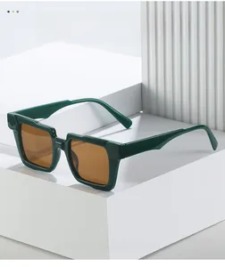 Detail view of dark green square sunglasses with brown lenses on geometric white stone