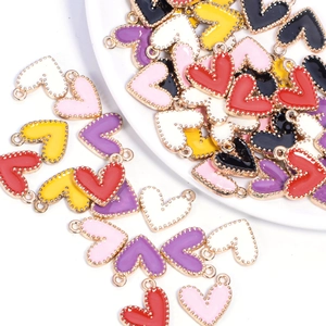 Macro shot of assorted colorful enamel heart pendants in a white ceramic dish