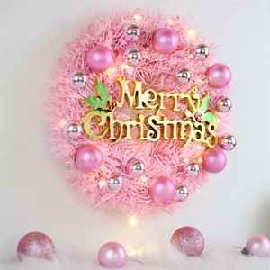 Pink Christmas wreath with LED lights, pink ornaments and golden Merry Christmas sign