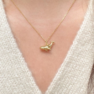 Minimalist 925 sterling silver whale pendant necklace in gold finish worn on sweater