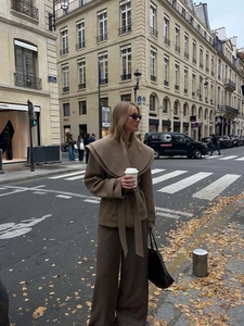 Details des khakifarbenen Wollmantels mit großem Revers und Taillengürtel im Streetstyle