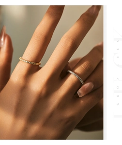 Close-up of gold and silver stackable diamond eternity rings worn on model fingers