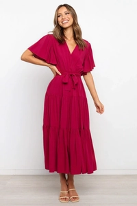 Detalle de vestido cruzado magenta con escote en V y dobladillo de volantes en capas