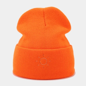 Detail of orange ribbed knit beanie featuring silver sun embroidery for outdoor warmth