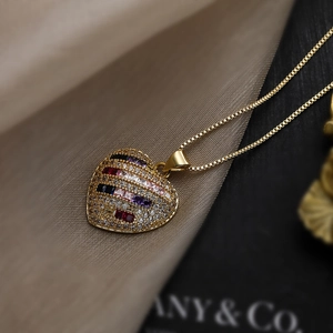 Detail of a gold-plated heart pendant necklace with colorful cubic zirconia pavé setting