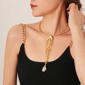 Macro shot of gold fishbone pendant with sparkling crystals and a pearl drop detail