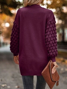 Detail view of plum purple cardigan featuring unique scale knit sleeves and soft texture