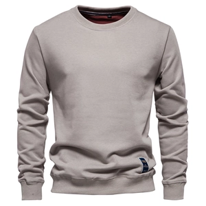 Detailed close-up of light grey crewneck sweatshirt with ribbed collar and brand tag