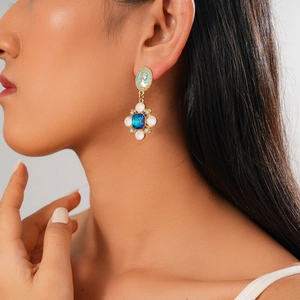 Detail of vintage bohemian flower cameo earrings with blue stones on a model