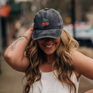 Close-up of vintage washed grey baseball cap with red cherry embroidery detail