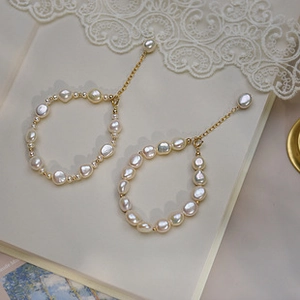 Detailansicht von Barockperlen-Armbändern mit 14K Vergoldung und elegantem Spitzenhintergrund