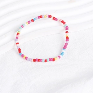 Macro detail of colorful Bohemian handmade seed bead layered bracelets on white background