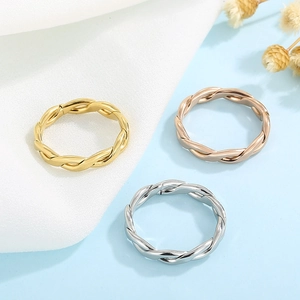 Detailed view of woven twist rings in gold, silver, and rose gold stainless steel