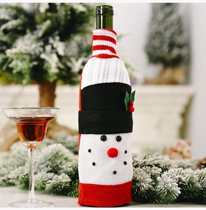 Close-up of a festive knitted snowman wine bottle cover with a striped scarf and belt