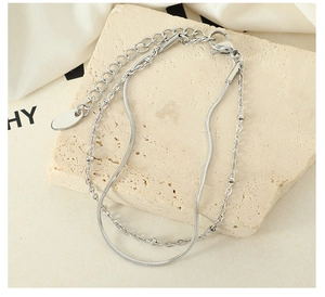 Close-up of double-layered silver chain bracelet with snake chain and bead details