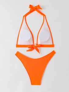 Flat lay of neon orange halter bikini with metal ring detail and high-waist bottoms