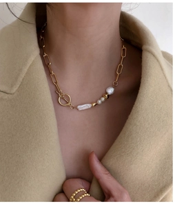 Baroque pearl and gold rectangle link necklace with toggle clasp on a model