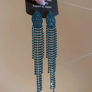 Detailed macro of dark blue rhinestone jellyfish tassel earrings with silver needle pins
