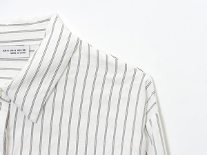 Detail view of white striped shirt collar with lace texture and size tag information