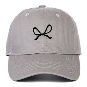 Close-up of embroidered black bow design on light gray cotton baseball cap crown