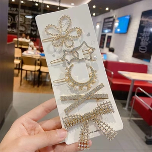 Detail of 5-piece gold hair clip set featuring pearls and rhinestones on card