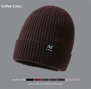 Detail of coffee brown ribbed knit beanie featuring an embroidered patch and color swatches
