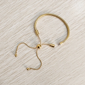 Detailed view of gold snake chain bracelet with adjustable slider and screw end closure