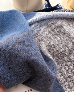 Close-up of blue and grey brushed knit scarf texture showing soft cashmere-like fringe fibers