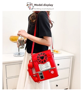 Red vintage rotary phone crossbody bag in shiny patent leather shown on model