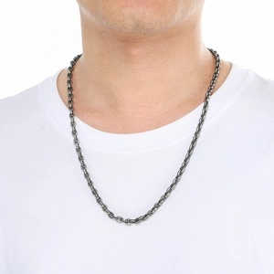 Close-up of polished silver oval link chain necklace worn on a model's neck