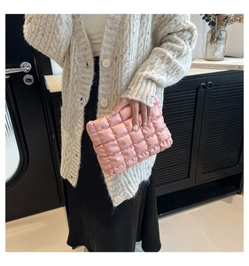 Vue détaillée du tissu en cuir PU rose matelassé et des coutures quadrillées d'un sac à main