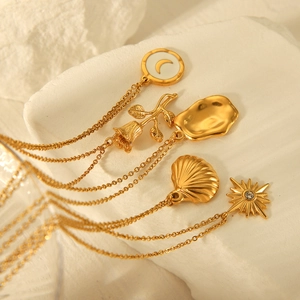 Detailed close-up of gold necklaces with moon, rose, shell, and star pendants