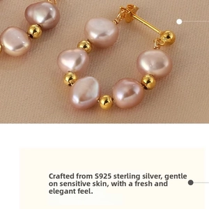 Macro shot of S925 sterling silver hoop earrings with baroque pearls on champagne satin