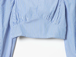Détail du haut à rayures bleues et blanches avec taille cintrée et coutures de précision