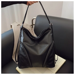 Detail of soft black PU leather shoulder bag with symmetrical zippers and large capacity