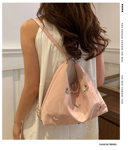 Back view of model wearing a pink large-capacity tote bag with metallic butterfly detail