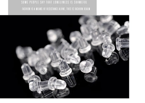 Macro shot of clear silicone earring backings scattered on a sleek black background