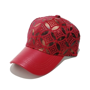 Detail view of red leather brim and golden geometric pattern on vintage baseball cap